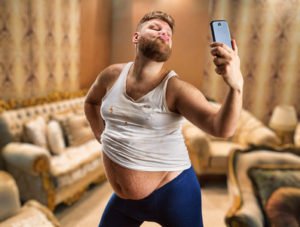 Fat glamour man with beard takes selfie in his bedroom
