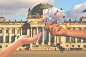 Reichstag und Hände, die Geld reichen